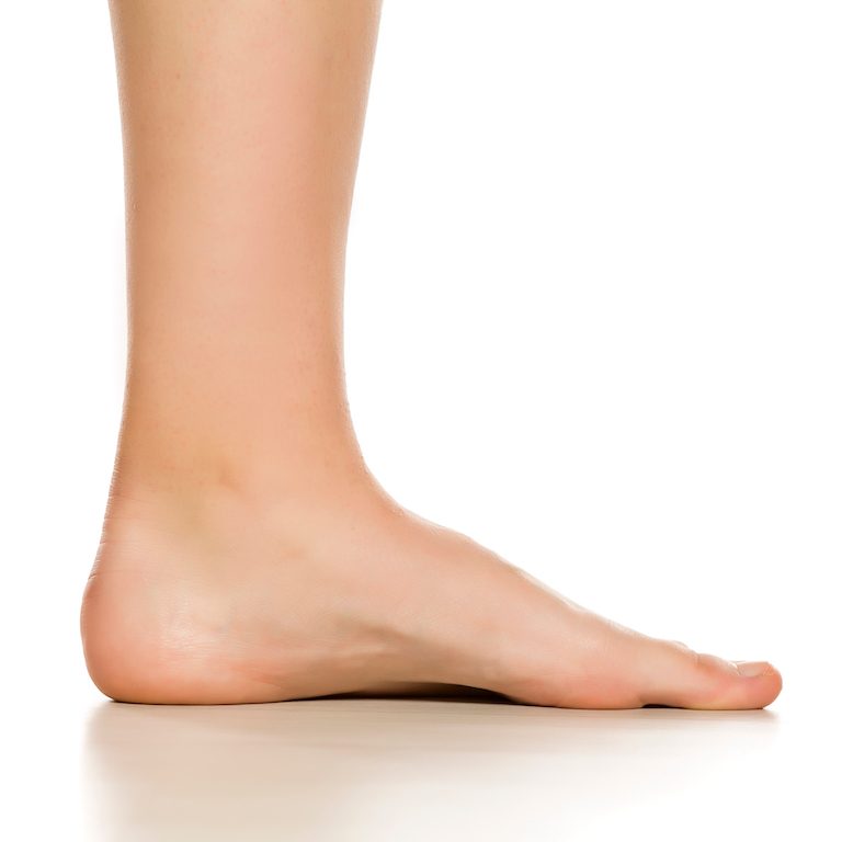 Side view of female bare foot on white background